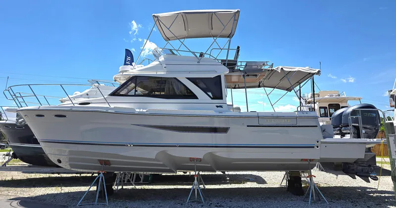 Slide: The Image of 2025 Cutwater C-32 CB boat displayed on stands under clear blue sky. - 1