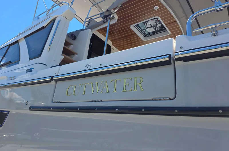 Slide: The Image of 2025 Cutwater C-32 CB boat, exterior view with nameplate, showcasing sleek design and craftsmanship. - 2