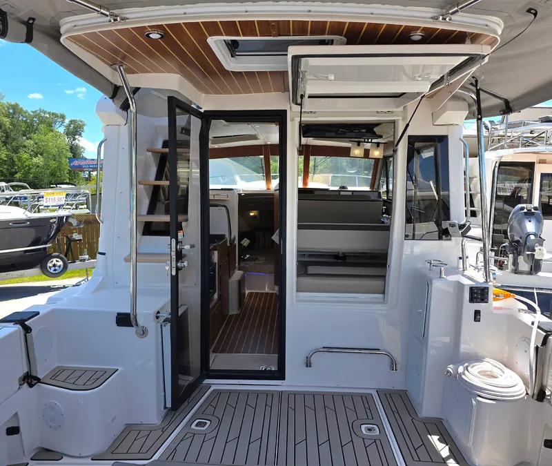 Slide: The Image of 2025 Cutwater C-32 CB boat interior with open doors and wood accents. - 5