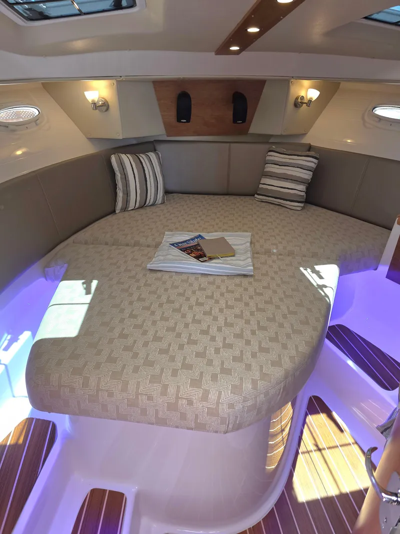 Slide: The Image of 2025 Cutwater C-32 CB cabin interior with cozy seating and ambient lighting. - 8