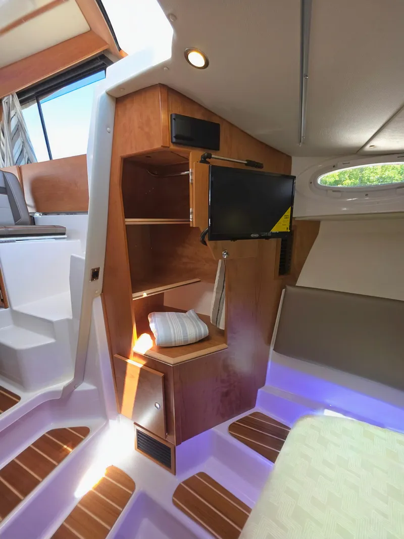 Slide: The Image of 2025 Cutwater C-32 CB interior with wood cabinetry, TV, and modern lighting. - 9