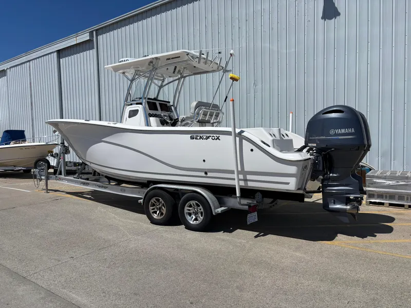 Slide: The Image of 2020 Sea Fox 266 Commander boat on trailer, parked near a large building. - 1
