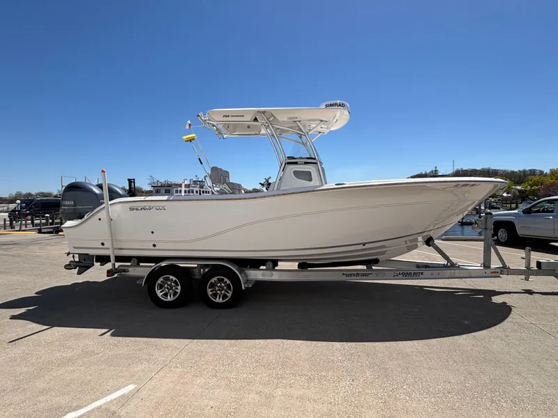 Slide: The Image of 2020 Sea Fox 266 Commander boat on trailer, parked outdoors under clear blue sky. - 2