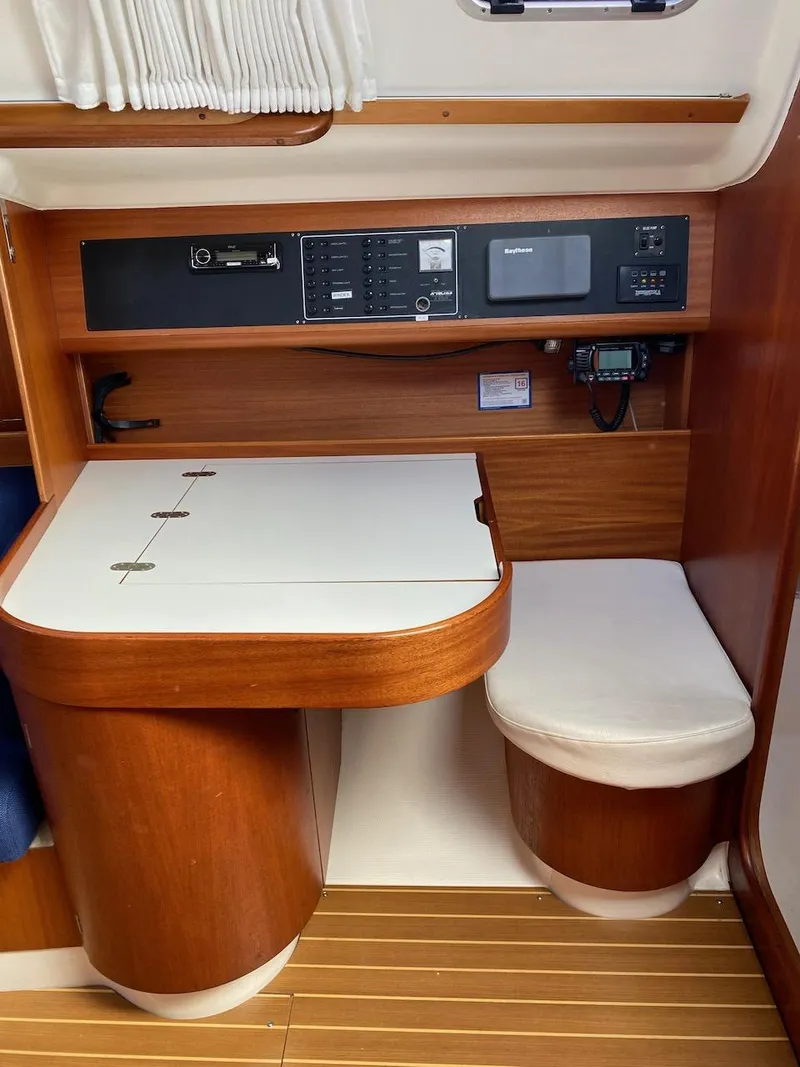 Slide: The Image of Interior of 2001 X-Yachts 332, featuring navigation station with wooden finish and modern equipment. - 19