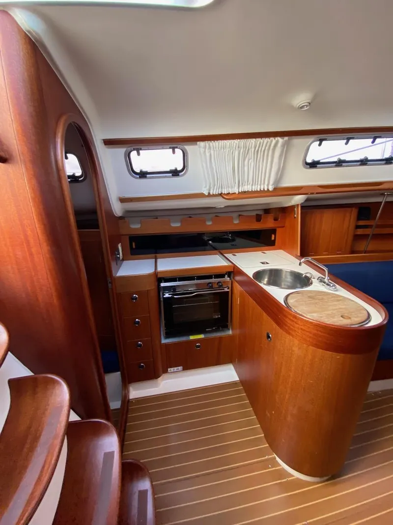Slide: The Image of Interior of 2001 X-Yachts 332 sailboat with wooden cabinetry and compact kitchen area. - 22