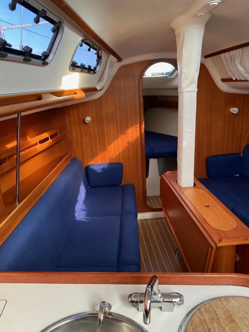 Slide: The Image of Interior of 2001 X-Yachts 332 sailboat with blue seating and wooden finishes. - 23