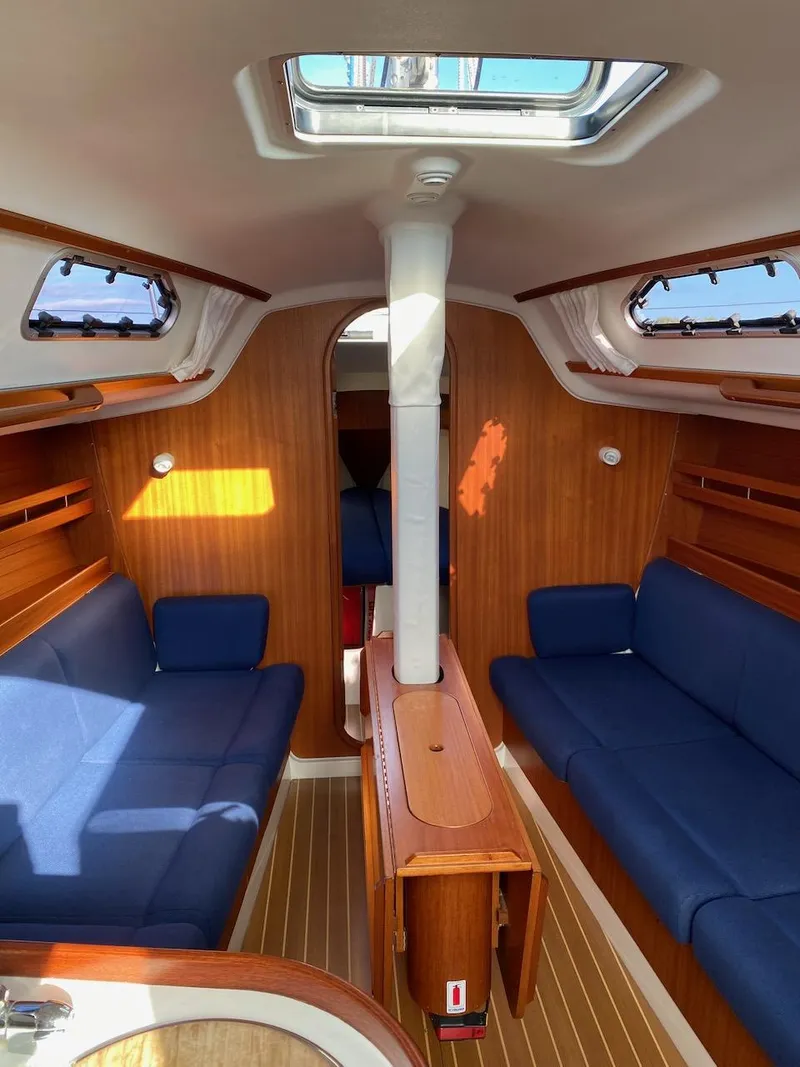 Slide: The Image of Interior of 2001 X-Yachts 332 sailboat with blue seating and wooden finishes. - 24