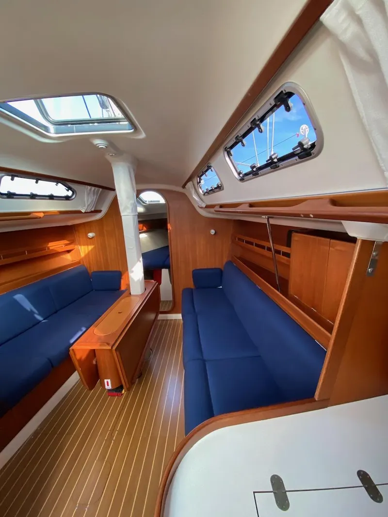 Slide: The Image of Interior of 2001 X-Yachts 332 sailboat with blue seating and wooden finishes. - 27