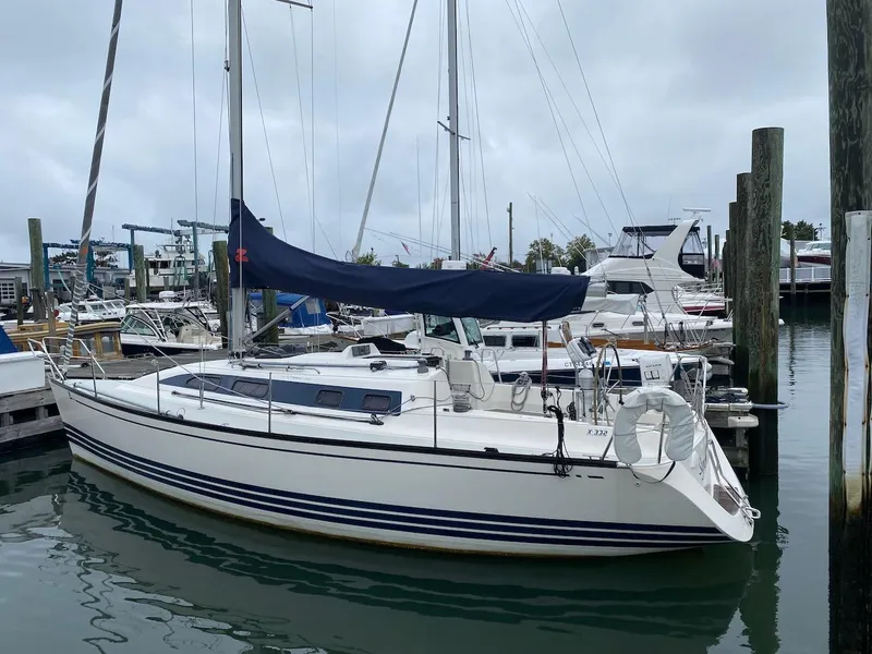 Slide: The Image of 2001 X-Yachts 332 sailboat docked in marina, featuring sleek design and blue sail cover. - 3
