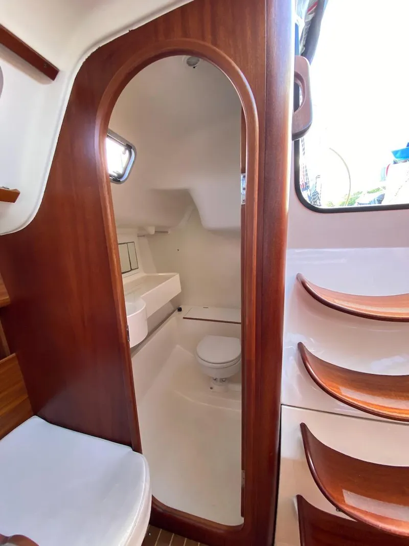 Slide: The Image of Interior of 2001 X-Yachts 332 sailboat featuring wooden cabinetry and compact bathroom. - 34