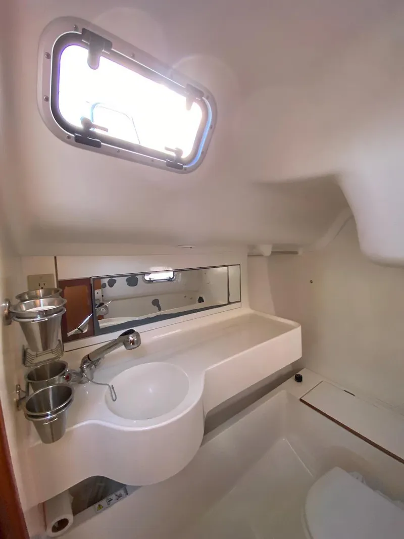 Slide: The Image of 2001 X-Yachts 332 bathroom interior with sink, mirror, and porthole window. - 36