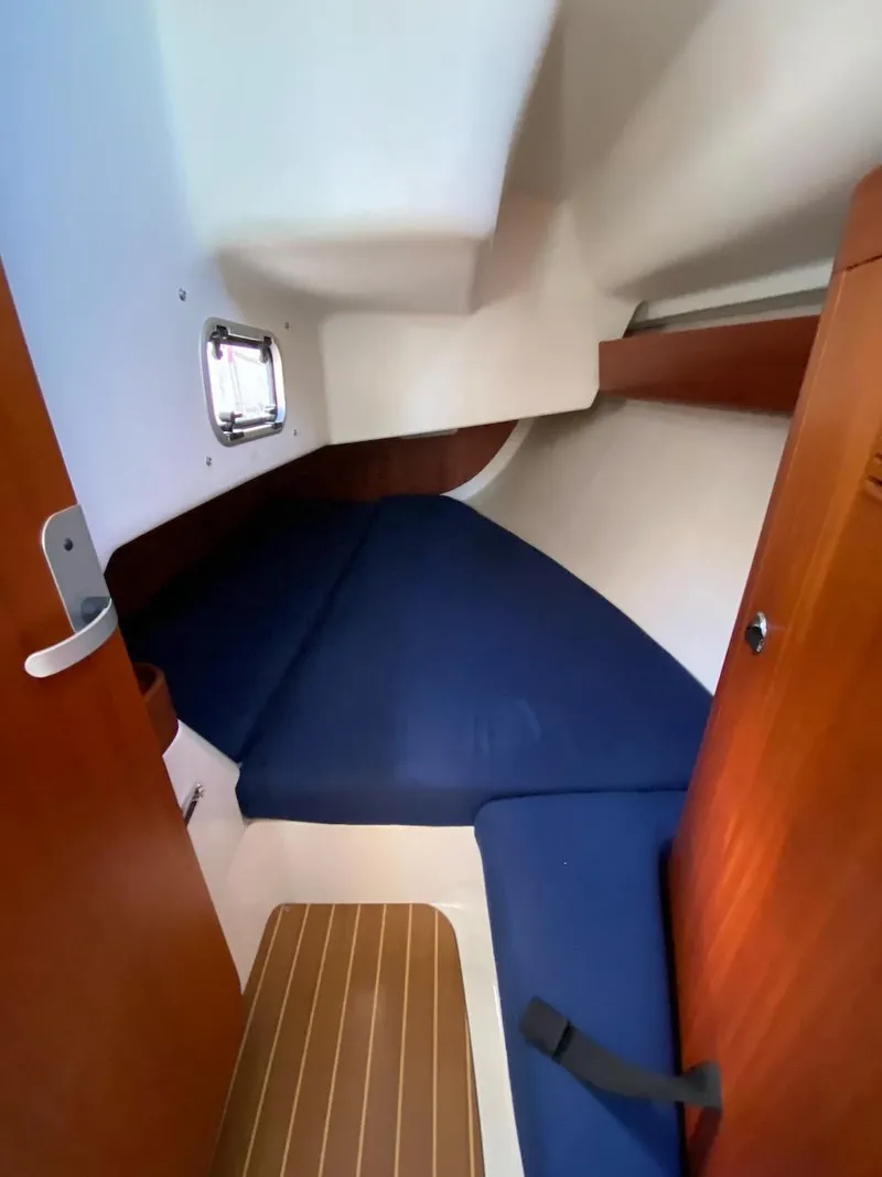 Slide: The Image of 2001 X-Yachts 332 cabin interior with blue cushions and wooden accents. - 37