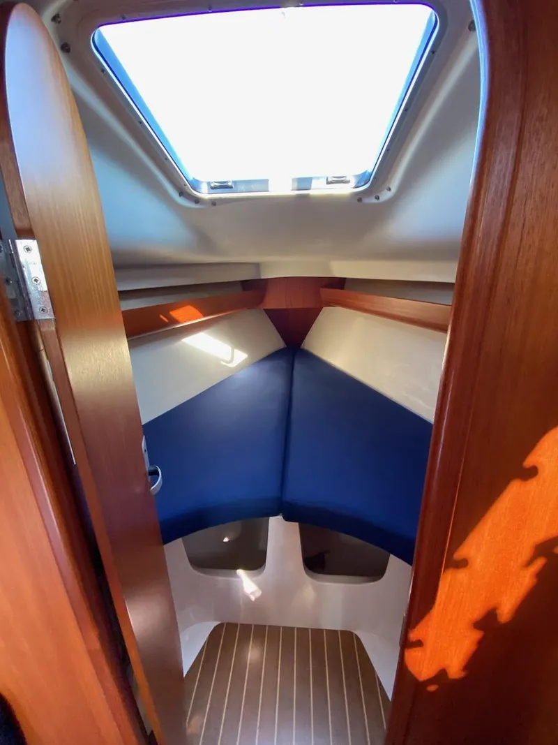 Slide: The Image of 2001 X-Yachts 332 cabin interior with blue cushions and wooden accents. - 39