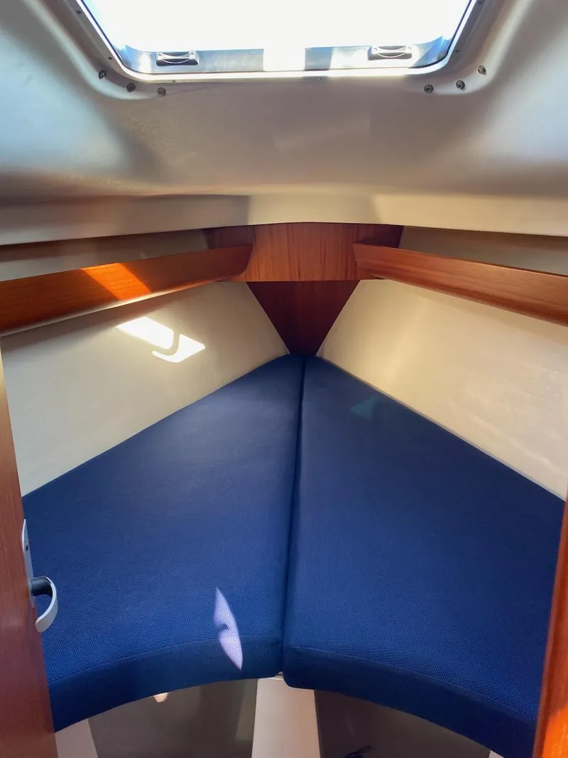 Slide: The Image of 2001 X-Yachts 332 interior cabin with blue cushions and wooden accents. - 40