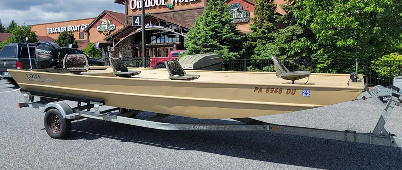 Slide: The Image of 2018 Lowe Roughneck 2070 Big River boat on trailer, parked outside outdoor store. - 0
