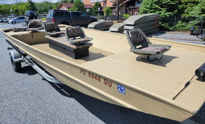 Slide: The Image of 2018 Lowe Roughneck 2070 Big River boat on trailer, featuring camouflage seats. - 2