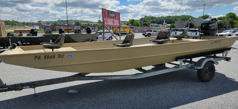 Slide: The Image of 2018 Lowe Roughneck 2070 Big River boat on trailer, parked outdoors under cloudy sky. - 7
