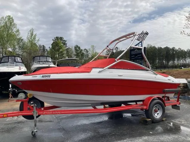 Slide: The Image of 2010 Four Winns H190 boat, red and white, on trailer, parked outdoors. - 12