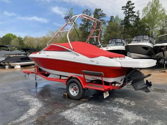 Slide: The Image of 2010 Four Winns H190 boat with red cover on trailer, parked outdoors. - 13