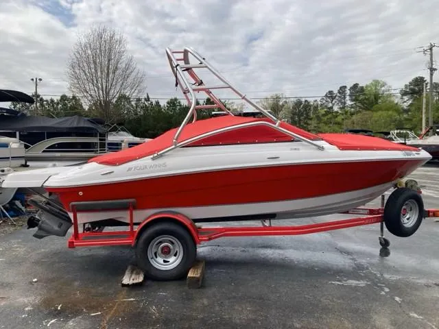 Slide: The Image of 2010 Four Winns H190 red and white boat on trailer, parked outdoors. - 15