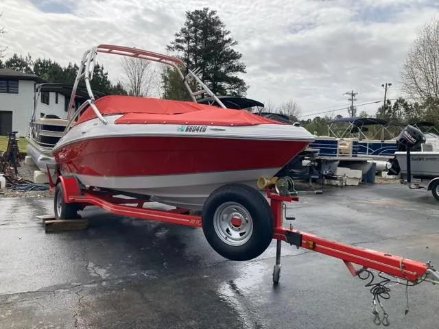 Slide: The Image of 2010 Four Winns H190 boat on trailer, red cover, parked outdoors. - 16