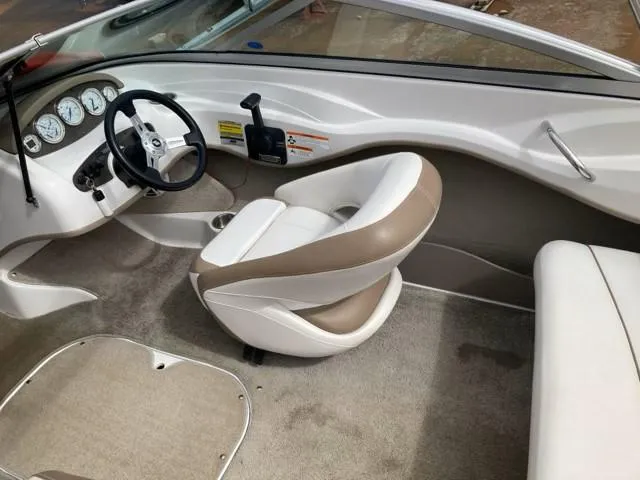 Slide: The Image of 2010 Four Winns H190 boat interior with steering wheel and beige seating. - 19