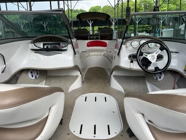 Slide: The Image of 2010 Four Winns H190 boat interior with dual steering wheels and beige seating. - 23