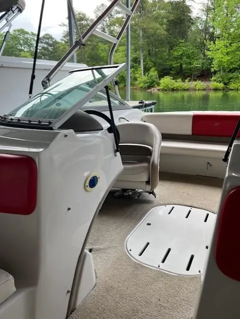 Slide: The Image of 2010 Four Winns H190 boat interior with seating, steering wheel, and lake view. - 24
