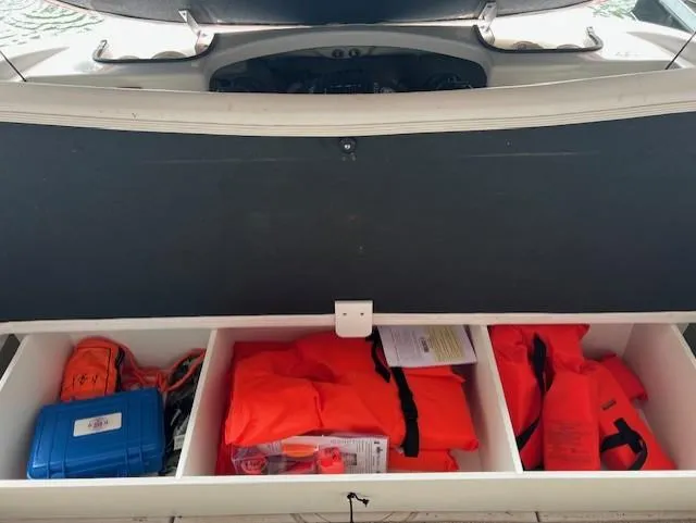 Slide: The Image of Storage compartment of 2010 Four Winns H190 boat with life jackets and safety gear. - 9
