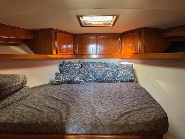 Slide: The Image of 1989 Egg Harbor 35 Sport Fisherman cabin with cozy bed and wooden cabinets. - 4