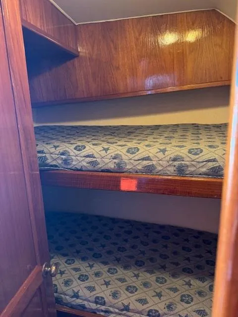 Slide: The Image of 1989 Egg Harbor 35 Sport Fisherman cabin with wooden interior and patterned bunk beds. - 6