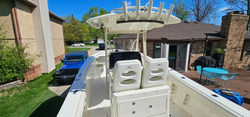 Slide: The Image of 2017 Cobia 277 Center Console boat with dual seats, parked in a residential driveway. - 14