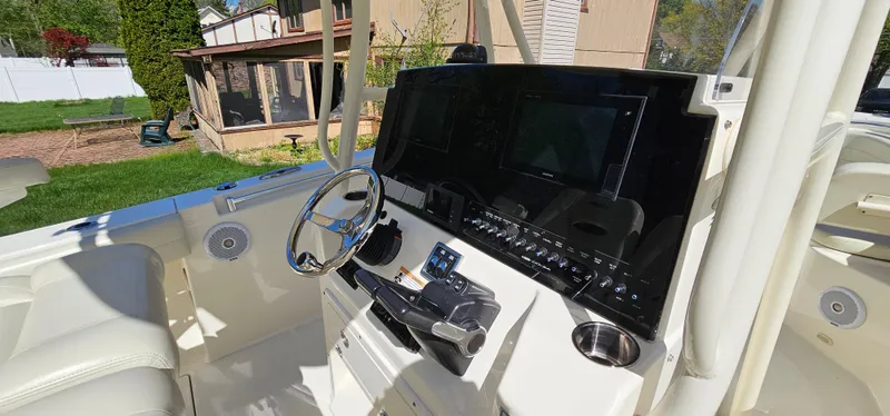 Slide: The Image of 2017 Cobia 277 Center Console boat dashboard with steering wheel and electronic displays. - 23