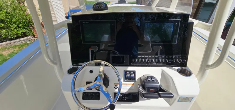 Slide: The Image of 2017 Cobia 277 Center Console boat dashboard with steering wheel and control panel. - 24
