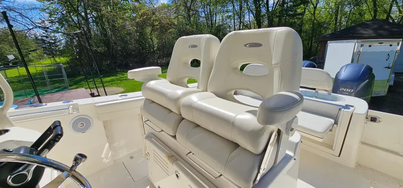 Slide: The Image of 2017 Cobia 277 Center Console boat with dual cushioned seats, outdoor setting. - 28