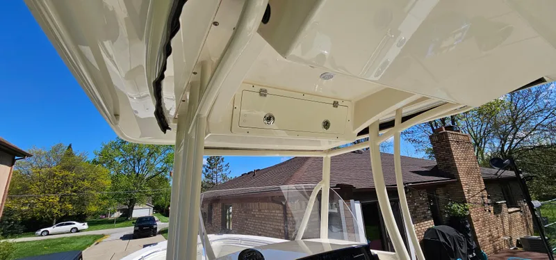Slide: The Image of 2017 Cobia 277 Center Console boat with T-top, parked in a residential driveway. - 34
