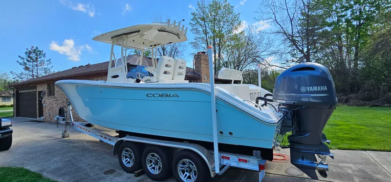 Slide: The Image of 2017 Cobia 277 Center Console boat on trailer with Yamaha engine, parked outdoors. - 4