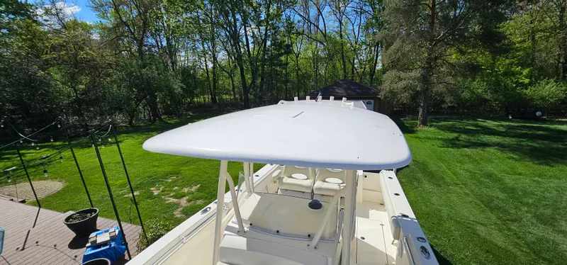 Slide: The Image of 2017 Cobia 277 Center Console boat in a lush green backyard setting. - 42