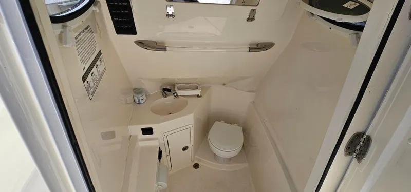Slide: The Image of 2017 Cobia 277 Center Console boat interior with compact bathroom amenities. - 44