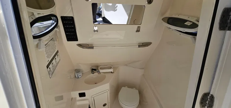 Slide: The Image of 2017 Cobia 277 Center Console boat interior with toilet and sink. - 45