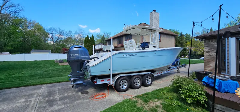 Slide: The Image of 2017 Cobia 277 Center Console boat on trailer in residential driveway. - 6