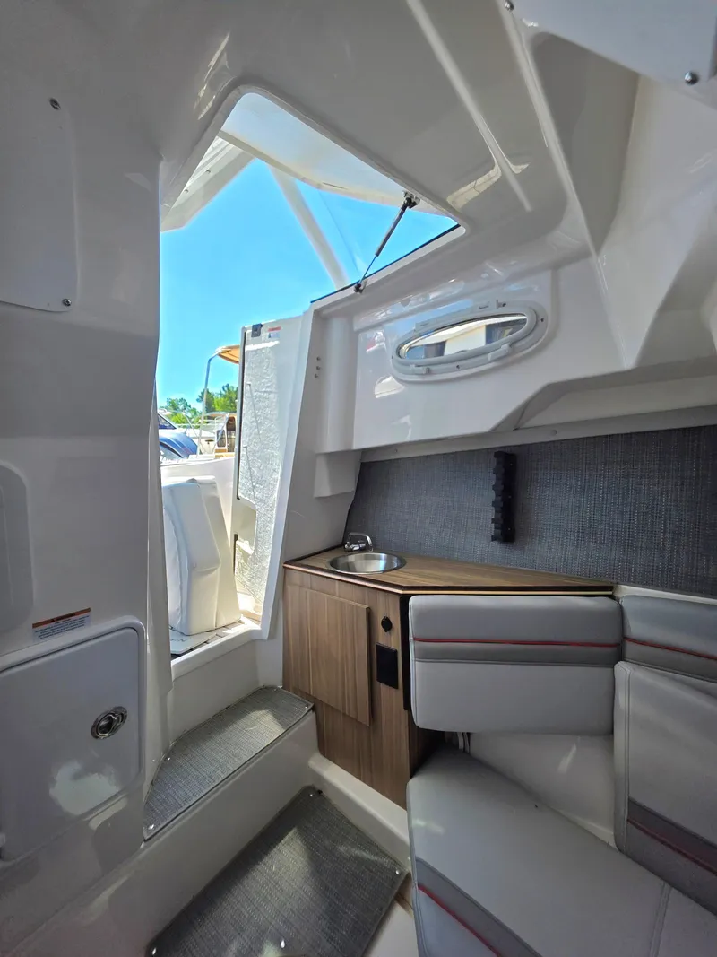 Slide: The Image of Interior of 2025 Solara S-250 CW boat, featuring seating and compact kitchenette. - 5