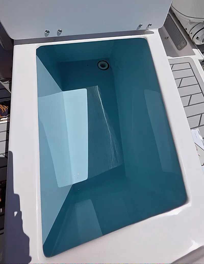 Slide: The Image of 2025 Solara S-250 CW boat livewell with clean water, open lid, and drain plug. - 9