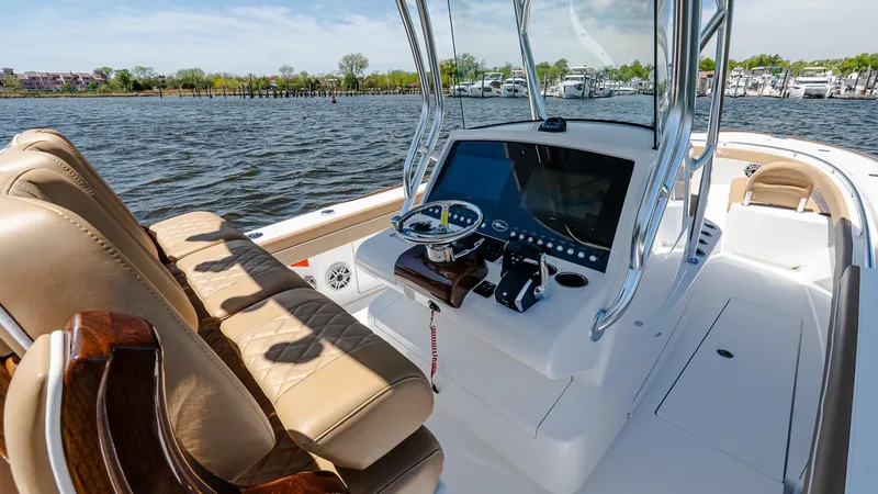 Slide: The Image of 2025 Valhalla Boatworks V-29 Hybrid with modern helm, luxurious seating, and scenic water backdrop. - 21