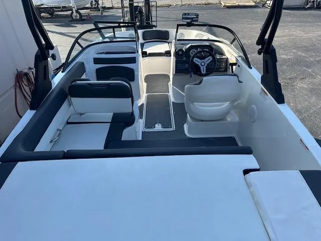 Slide: The Image of 2021 Bayliner VR5 Bowrider I/O interior with seating and steering wheel, docked outdoors. - 5