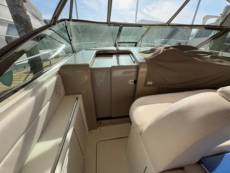 Slide: The Image of 1999 Sea Ray 410 Express Cruiser interior with beige seating and covered dashboard. - 11