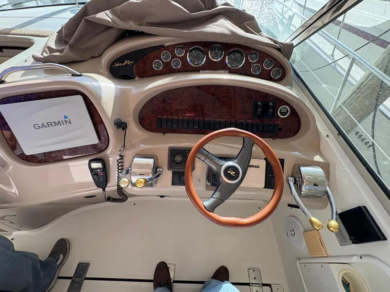 Slide: The Image of 1999 Sea Ray 410 Express Cruiser helm with Garmin navigation and wood-accented steering wheel. - 14