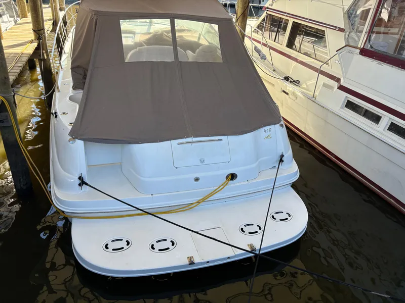 Slide: The Image of 1999 Sea Ray 410 Express Cruiser docked, featuring a covered cockpit and spacious swim platform. - 16