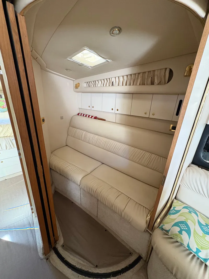 Slide: The Image of 1999 Sea Ray 410 Express Cruiser interior with beige seating and overhead storage. - 2