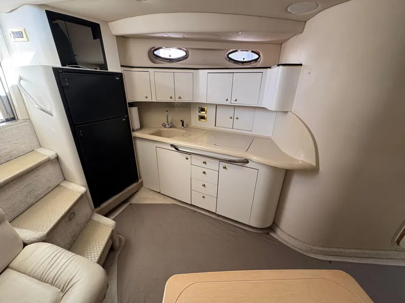 Slide: The Image of 1999 Sea Ray 410 Express Cruiser interior with kitchenette and seating area. - 3